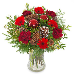 Bukett med röda nejlikor, röda gerberas, kottar, julkula och grönt. Skicka julbuketten med ett blomsterbud från Euroflorist och önska God Jul!