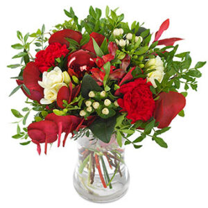Bukett med vit freesia, röda nejlikor samt gröna blad. Ur Euroflorists julsortiment.