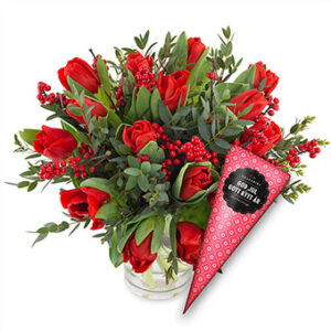 Julbukett med röda tulpaner, röda bär och grönt. Plus en strut med choklad. Ur Euroflorists julsortiment.