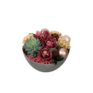 Liten juldekoration i rund skål, med vinröda orkidéer, rosépeppar, julkulor och grönt. Juldekorationen ingår i Interfloras julsortiment.