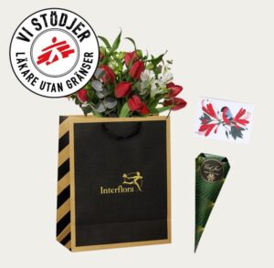 Presentpåse med blommor, choklad och ett julkort. Beställ online hos Interflora!